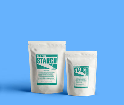 Two white stand-up pouches of Scenic Starch, one larger and one smaller, standing against a solid blue background. Both packages feature a teal and white label with the brand name 'SCENIC STARCH' and product details. Product sizes muslin backdrops for theatrical scenery.