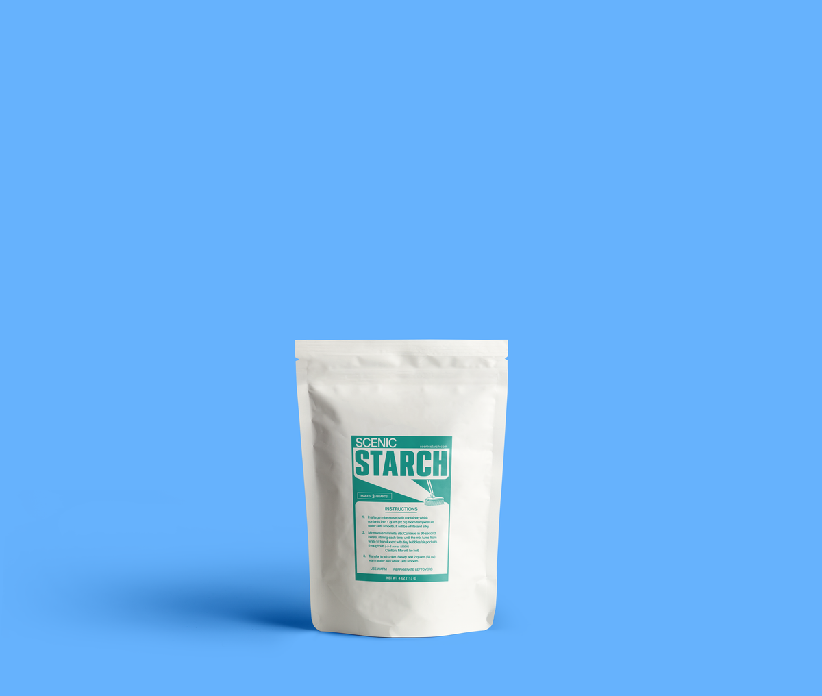 One white stand-up pouch of Scenic Starch stands against a solid blue background. Package features a teal and white label with the brand name 'SCENIC STARCH' and product details. Product sizes/prepares muslin backdrops for theatrical scenery.